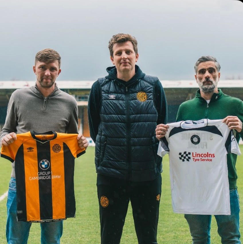 Stevenage Futsal and Cambridge United FC representatives holding both clubs' shirts at the partnership announcement